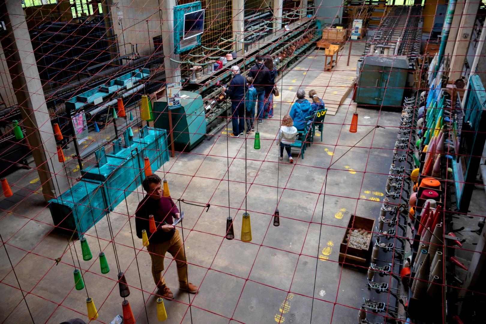 Bezoekers bekijken historische spinmachines in de wolspinnerij van Belvès