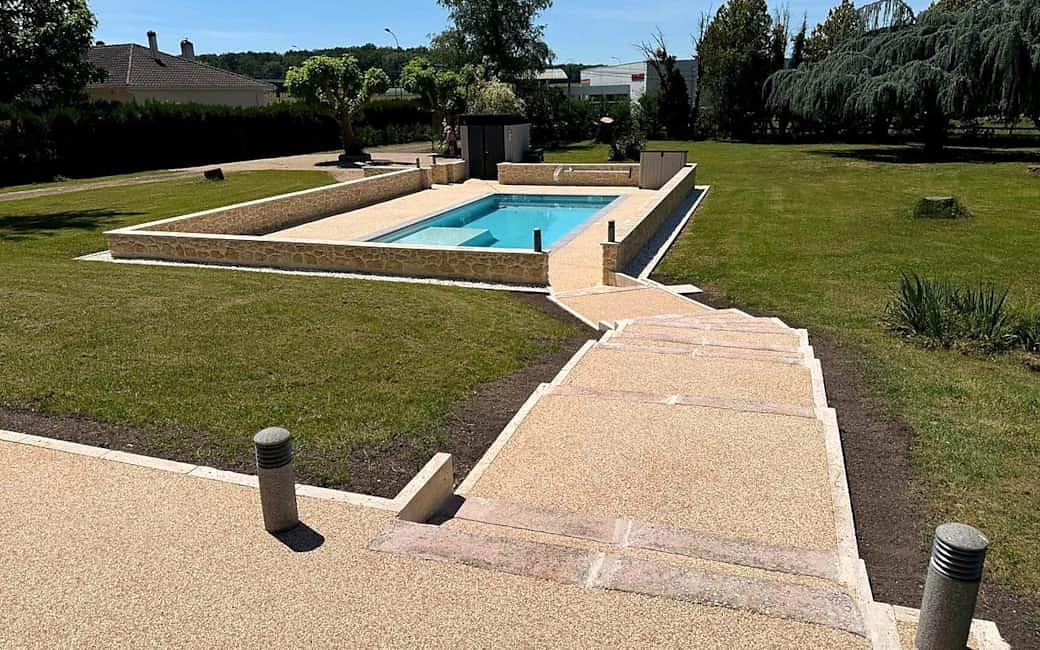 Stone garden steps leading down to the swimming pool, with the lawn and trees beyond