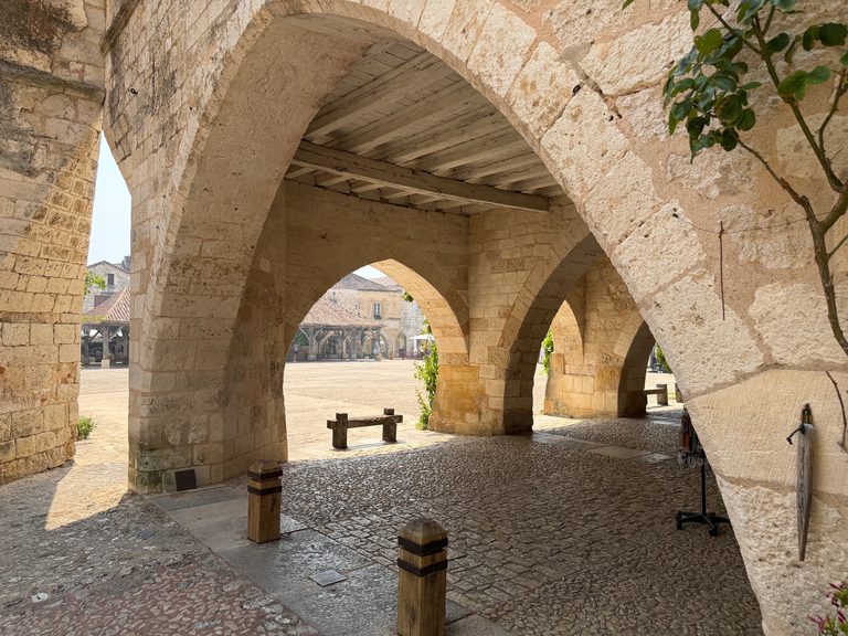 Steinerne Arkaden mit Blick auf die Markthalle am Place des Cornières in Monpazier