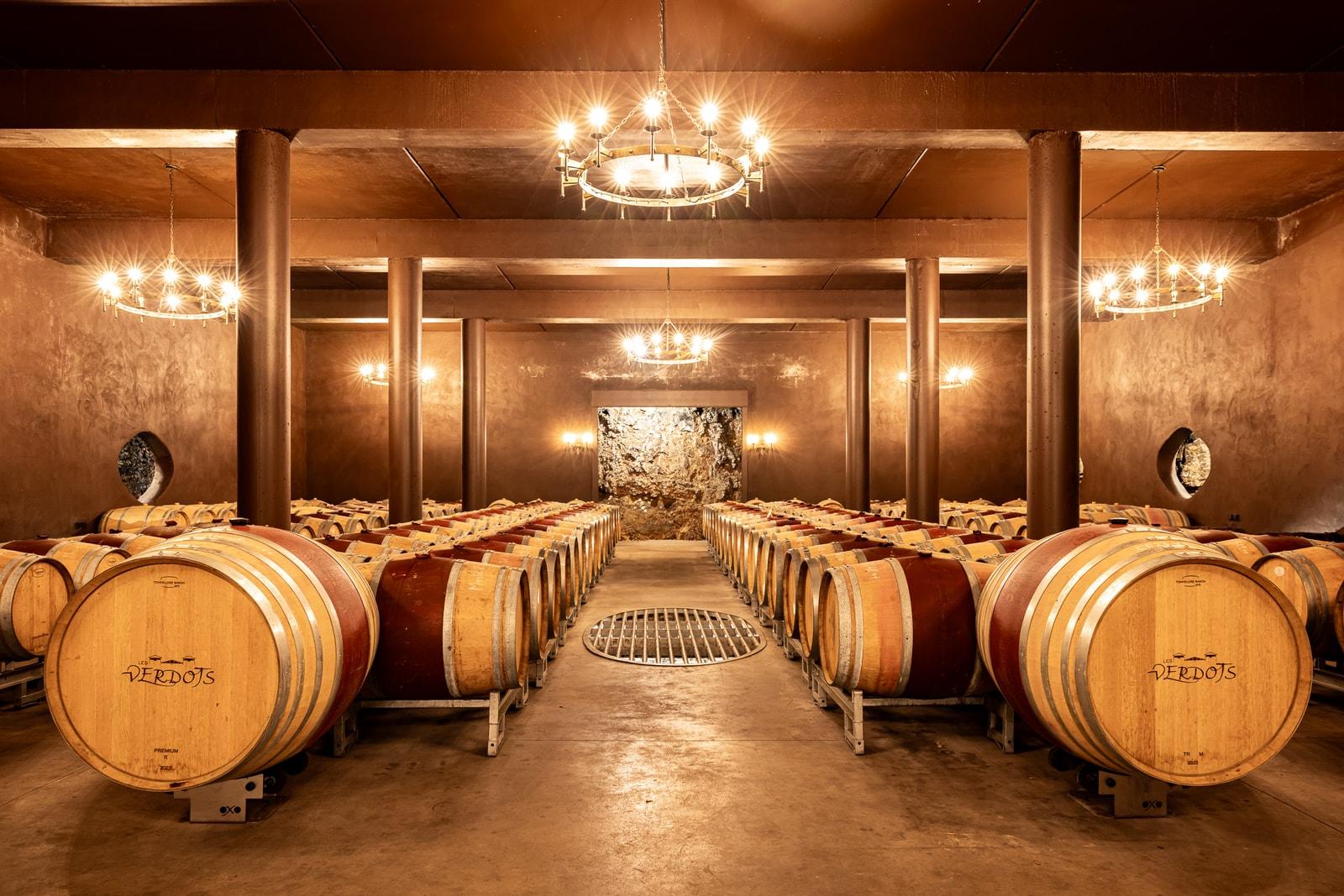 Rows of oak barrels in the underground cellar at Les Verdots