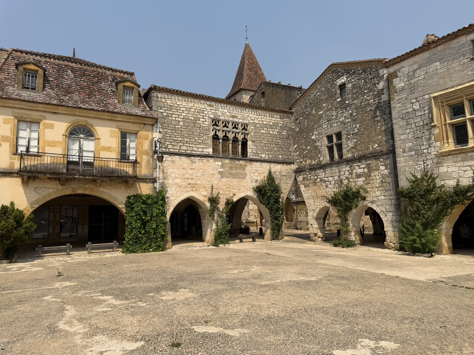 Several adjoining stone façades and ground-floor arcades around Place des Cornières in Monpazier