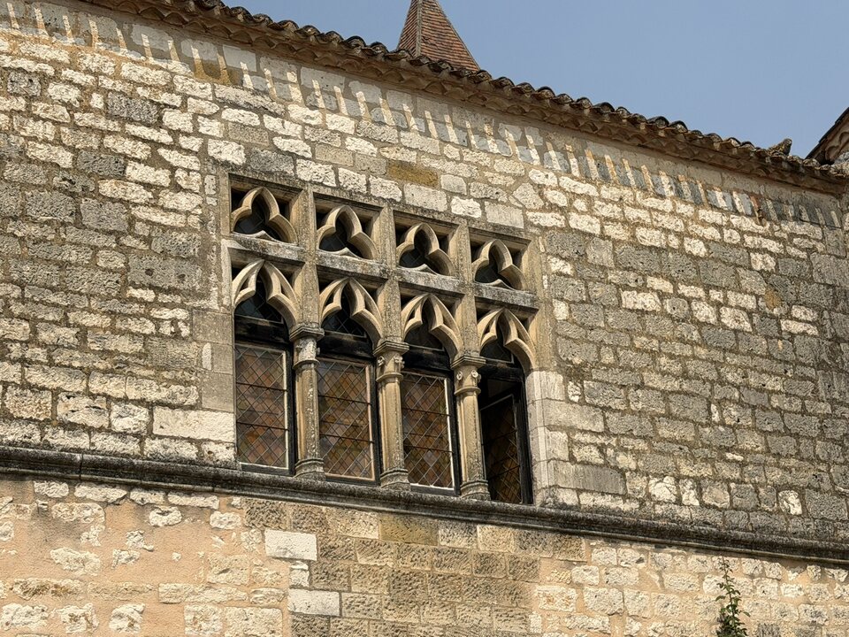 Carved stone window in Monpazier with a moulded surround and decorative details